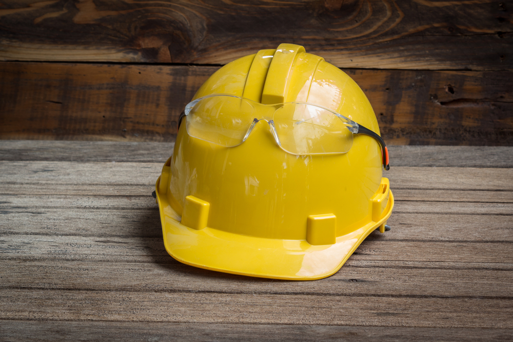 Hard-Hat-and-safety-glasses-on-wooden-background