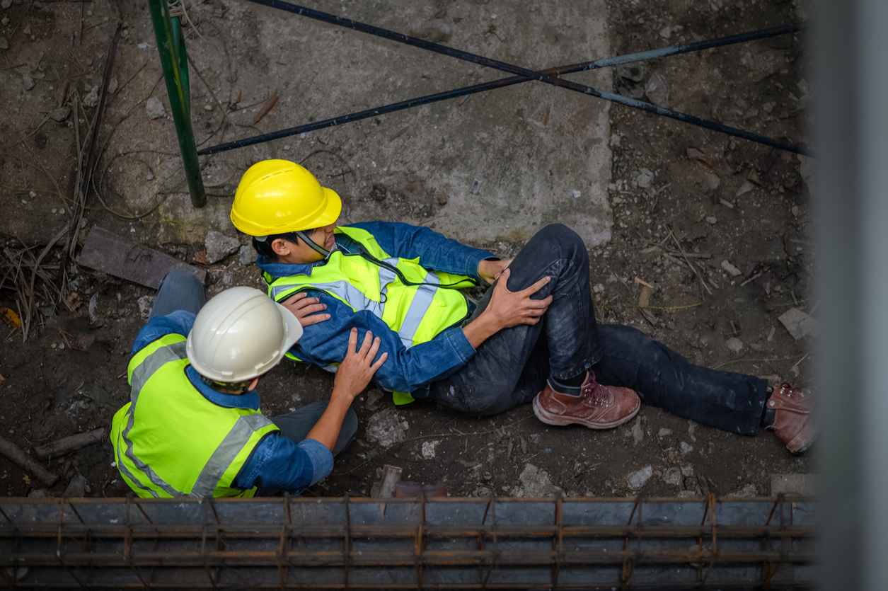 man laying on the ground grabbing his knee after falling from scaffolding. Can I sue my employer for a personal injury?